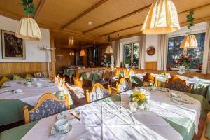 ein Esszimmer mit Tischen und Stühlen mit Blumen in der Unterkunft Gasthaus zum Rebstock in Kressbronn am Bodensee
