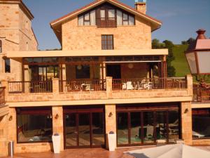 a large building with a balcony on top of it at Posada La Torre de los Isla & Spa in Beranga