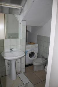 a bathroom with a sink and a washing machine and a toilet at Appartamento Prima Fila mare in Cupra Marittima