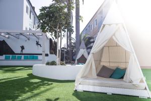 - un lit en tipi dans une cour avec de l'herbe dans l'établissement Corralejo Surfing Colors Hotel&Apartments, à Corralejo