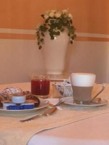 una mesa con un plato de comida y una taza de café en Su Recreu, en Bosa Marina