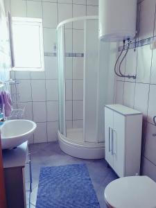 a bathroom with a shower and a toilet and a sink at Apartment Sun in Novalja +55 photos