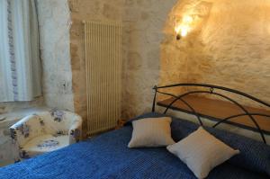 a bedroom with a bed and a chair at Il Borgo Delle Querce Villa Fichi Piscina privata in Martina Franca +29 photos