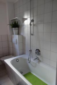 bagno con vasca e doccia di Ferienhaus Quick's Cottage a Roetgen
