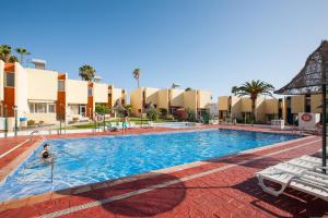 a swimming pool at a resort with a person in it at Apartamentos El Cortijo in Playa de las Americas