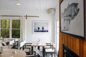 a dining room with tables and chairs and a fireplace at Sole East Resort in Montauk