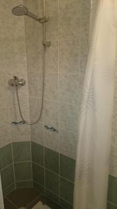 a shower with a white shower curtain in a bathroom at Študio Apartman Jakobyho in Košice