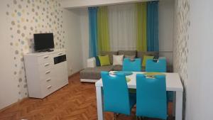 a living room with a table and blue chairs at Študio Apartman Jakobyho in Košice