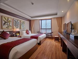 a hotel room with two beds and a television at Sapa Freesia Hotel in Sa Pa