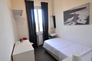 a small bedroom with a bed and a window at Hotel Belsoggiorno in Quercianella