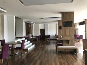 a dining room with wooden tables and purple chairs at Hande Hotel in Mustafakemalpaşa