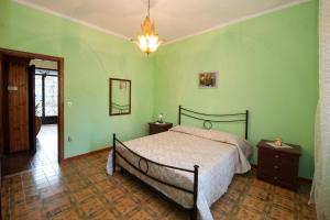 Schlafzimmer mit einem Bett mit grünen Wänden und einem Kronleuchter in der Unterkunft Casa Vacanze Del Core in Tramonti