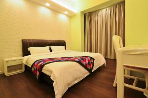 a bedroom with a bed and a table in it at Jetty Suites Apartments in Malacca