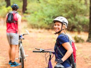 een vrouw die naast een fiets op een pad staat bij Warthogs Bush Lodge in Magaliesburg