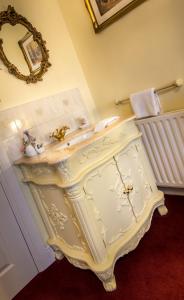 a white bathroom with a sink and a mirror at Creston Villa Guest House in Lincoln