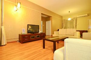 a living room with a television and a table at Jetty Suites Apartments in Malacca