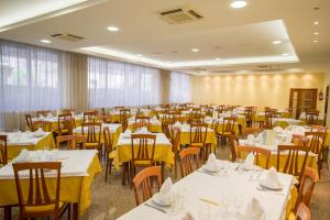 a dining room with tables and chairs with yellow tablecloths at Hotel International in Tortoreto Lido