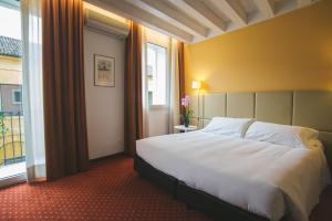 
a hotel room with a bed and a window at Relais Santa Corona in Vicenza
