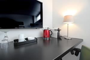 einem Tisch mit einer Lampe und einer Kaffeemaschine darauf in der Unterkunft Guesthouse Prinsencanal 2 in Amsterdam