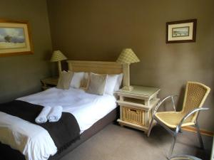 um quarto de hotel com duas camas e uma cadeira em Mountainview Inn em Harrismith