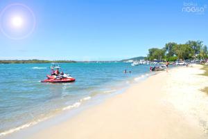 un grupo de personas en barcos en una playa en Noosa Village River Resort en Noosaville