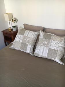 a bed with two pillows on top of it at Appartment Le Charme du Bourgeois in Nice