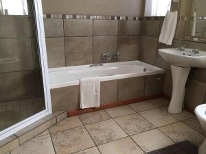 Mountainview Inn في هاريسميذ: حمام مع حوض استحمام ومغسلة