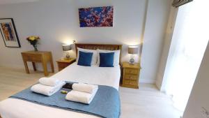 1 dormitorio con 1 cama con toallas en Signet Apartments - Vesta en Cambridge