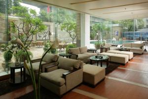 a lobby with couches and tables and windows at Jaypee Siddharth in New Delhi
