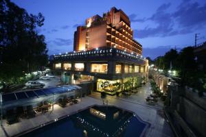 a building with a pool in front of it at night at Jaypee Siddharth in New Delhi