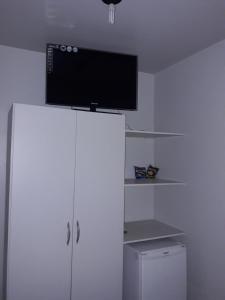 a white cabinet with a television on top of it at Hotel Master in Primavera do Leste