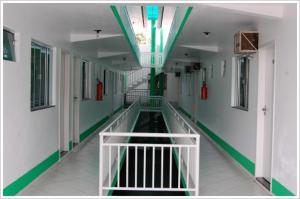 an empty corridor of a hospital hallway with a green stripe at Hotel Master in Primavera do Leste