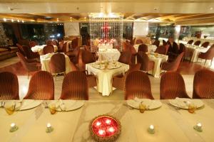 a dining room with tables and chairs and a chandelier at Jaypee Siddharth in New Delhi +37 photos