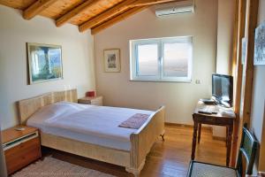 a bedroom with a bed and a desk and a television at Villa Mos in Kalamata +38 photos
