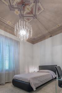 a bedroom with a bed and a chandelier at B&B Relais Paradise in Pisa