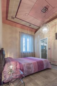 sypialnia z dużym łóżkiem z fioletową narzutą w obiekcie B&B Relais Paradise w Pizie