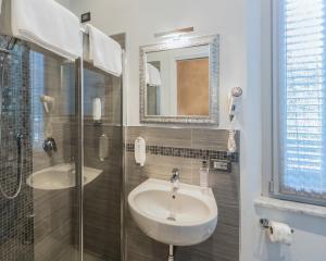 a bathroom with a sink and a shower and a mirror at B&B Relais Paradise in Pisa