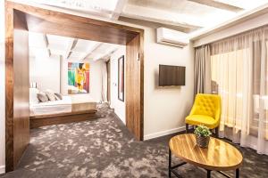 貝爾格勒的住宿－諾曼豪華套房旅館，酒店客房,配有床和黄色椅子