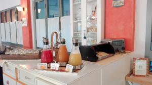 a kitchen counter with two bottles of juice and a toaster at Hotel Morgana in Marina di Carrara