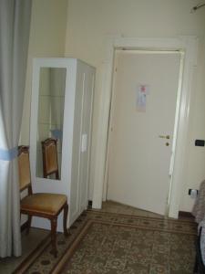 a room with a door and a chair and a mirror at B&B La Quiete in Albavilla