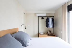 ein Schlafzimmer mit einem weißen Bett und einem Schrank in der Unterkunft thesuites Sevilla in Sevilla