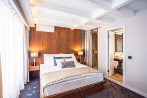 a bedroom with a large bed with a wooden wall at Nomad Luxury Suites in Belgrade