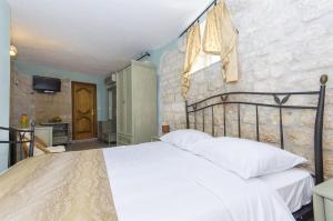 a bedroom with a large bed with white sheets at Palace Derossi in Trogir