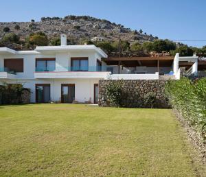 a large white house with a grass yard at Luxury Villa Verna in Líndos
