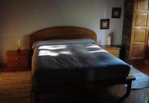 Doncos的住宿－Casa dos Pedrouzos，一间卧室配有一张带木制床头板的床