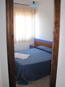 a bedroom with a blue bed and a window at Panorama Residence in Scalea