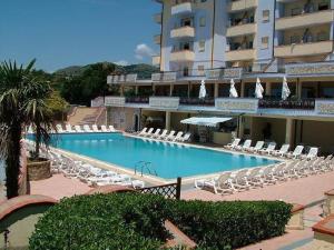 a large swimming pool with lounge chairs and a hotel at Panorama Apartments in Scalea