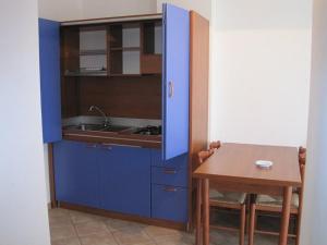 a small kitchen with a blue cabinet and a table at Panorama Apartments in Scalea
