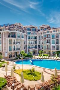 an image of a large apartment building with a swimming pool at Izida Palace Apartments in Sunny Beach