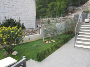 a garden with a staircase and a yard with flowers at Luxurious Apartments Maslina with Beach in Milna